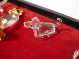 quelques figurines en verre sont posées sur une nappe rouge