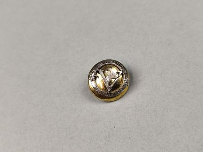 un gros plan d'un bouton en métal sur une surface blanche