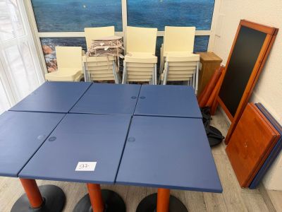 a blue table with four chairs and a chalk board on it