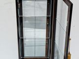 a glass display case with a door open on a white surface