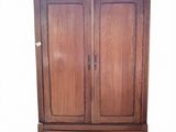 a wooden armoire with two drawers on top of it