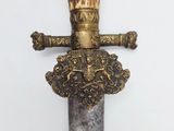 a close up of a sword with a crown on it