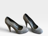 une paire de chaussures à talons hauts pour femme posée sur une surface blanche