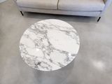 a white marble table on the floor in a living room
