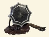a statue of a woman holding an umbrella on top of a table
