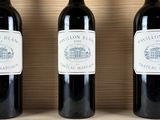 three bottles of wine sit on top of a wooden box