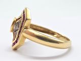 a close up of a gold ring with a diamond and a purple stone