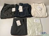 four pairs of men ' s pants are lined up on a table