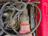 a red box with a cord and a drill in it