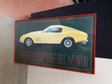 une photo d'une voiture de sport jaune accrochée au mur