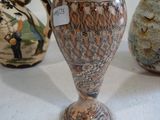 trois vases sont alignés sur une surface blanche, accompagnés d'une étiquette de prix