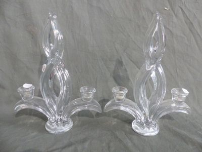 pair of clear glass candlesticks on a grey background