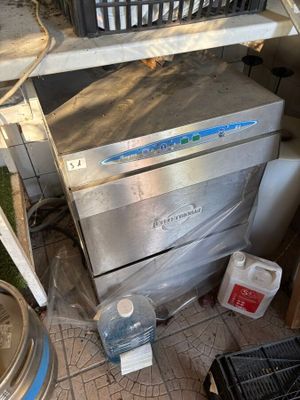 une photo d'une cuisine sale avec un lave-vaisselle et d'autres objets