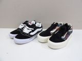 two pairs of black and white sneakers on a white surface