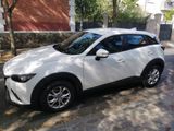 a white mazda cx - 3 parked on the side of the street