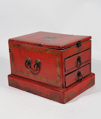 une petite commode rouge à trois tiroirs