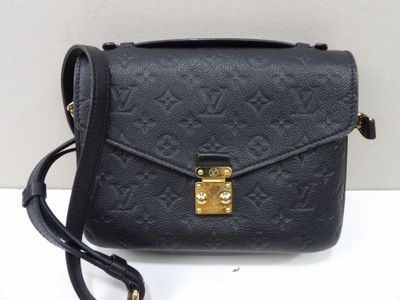 un sac à bandoulière Louis Vuitton noir avec des finitions dorées
