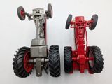 a red toy tractor and a red toy tractor on a white surface
