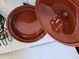 a brown bowl sitting on top of a table next to a wire rack