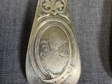 an old spoon with a silver handle sitting on top of a blue cloth