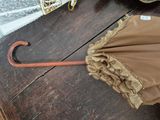 a brown umbrella with ruffles on it on a wooden table