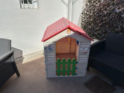 a small dog house with a red roof on the patio