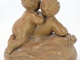 a small statue of a boy and a girl laying on top of a coin
