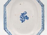 une vieille assiette bleue et blanche ornée d'un motif floral