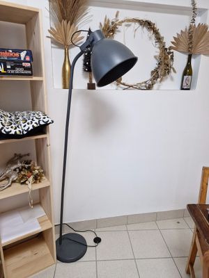 Lampe filaire en métal gris et une petite table en bois pein…