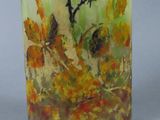 a glass vase with a painting on it sitting on a table