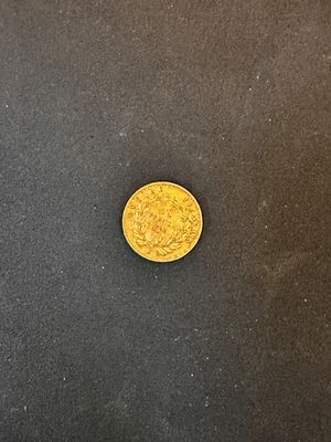 une pièce d'or posée sur une surface noire