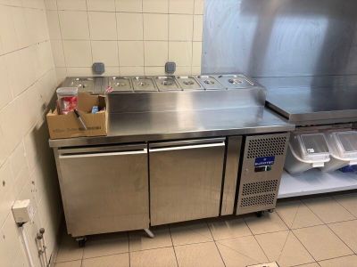 a stainless steel kitchen with a sink and a refrigerator