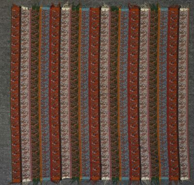 un gros plan sur un tapis rayé rouge et bleu avec des franges