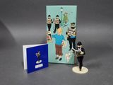 a figurine of a man holding a newspaper and a book