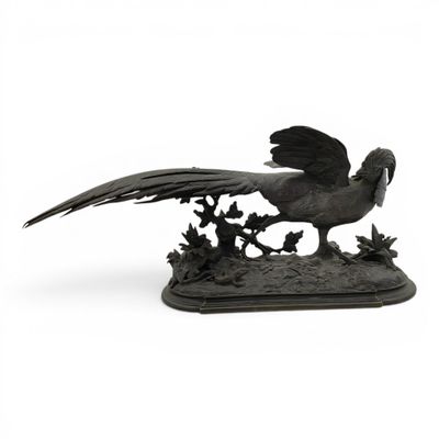 statue représentant un oiseau perché sur un rocher, avec un arbre en arrière-plan