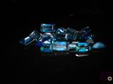 a pile of blue crystal stones on a black surface