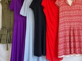 several different colored dresses hanging on a clothes rack in a room
