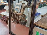 a large mirror in the middle of a room with pictures on the wall