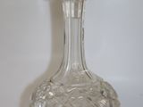 une carafe en verre posée sur une surface blanche
