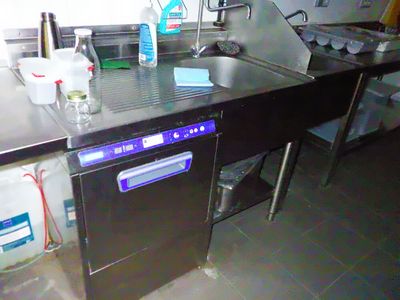 une cuisine équipée d'un évier, d'un lave-vaisselle et d'autres éléments posés sur le plan de travail