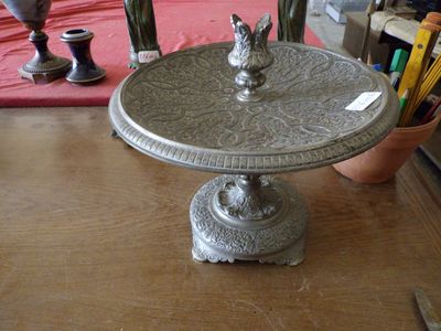 un plateau en argent orné d'un oiseau, posé sur une table