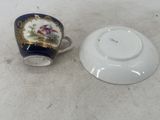 a cup and saucer sitting on the floor next to each other