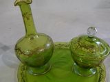 une assiette verte sur laquelle se trouvent une bouteille en verre et une autre assiette verte sur laquelle est posée une carafe en verre