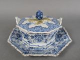an antique blue and white bowl and saucer on a saucer