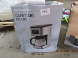 packaging of a coffee maker sitting on a table next to a cardboard box