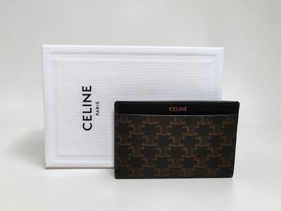a brown and black wallet sitting next to a white box
