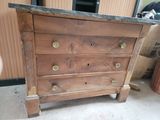a wooden chest of drawers with a marble top