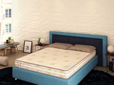 un lit qui se trouve dans une chambre avec une tête de lit bleue