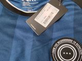a blue and black soccer jersey with a tag on it