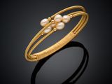 un bracelet en or orné de perles sur fond noir